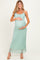 woman wearing a light green lace maternity maxi dress and gently cradling her baby bump