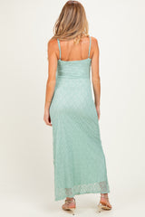 woman wearing a light green lace maternity maxi dress with thin straps, showing a baby bump from the back