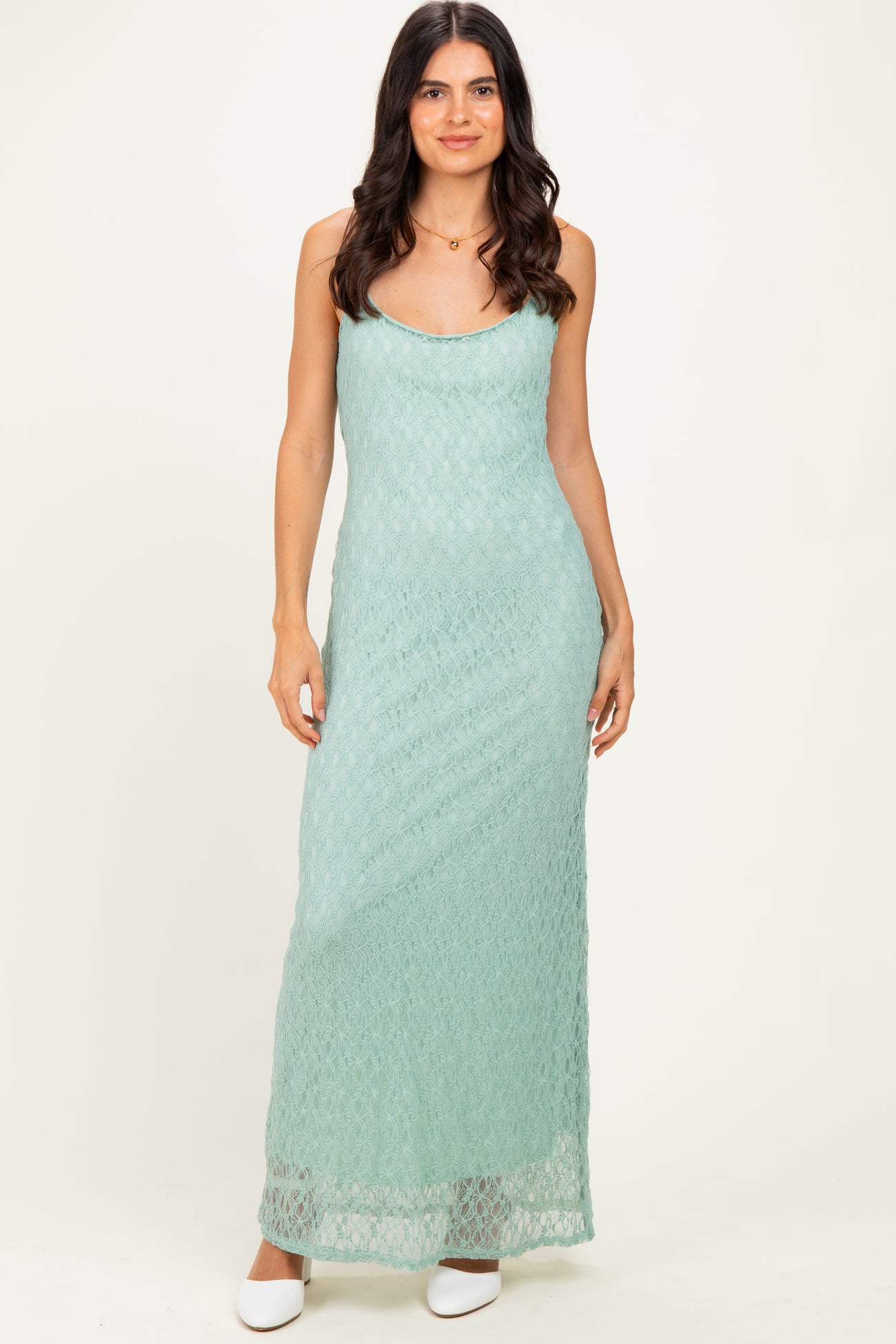 woman wearing a mint green lace maxi dress with a scoop neckline and spaghetti straps
