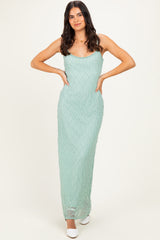 woman wearing a mint green lace maxi dress with a fitted silhouette and thin straps