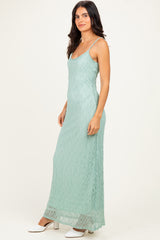 woman wearing a light green lace maxi dress with thin straps and a fitted silhouette