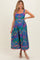 woman wearing a colorful floral printed maternity dress with a square neckline and lace trim details