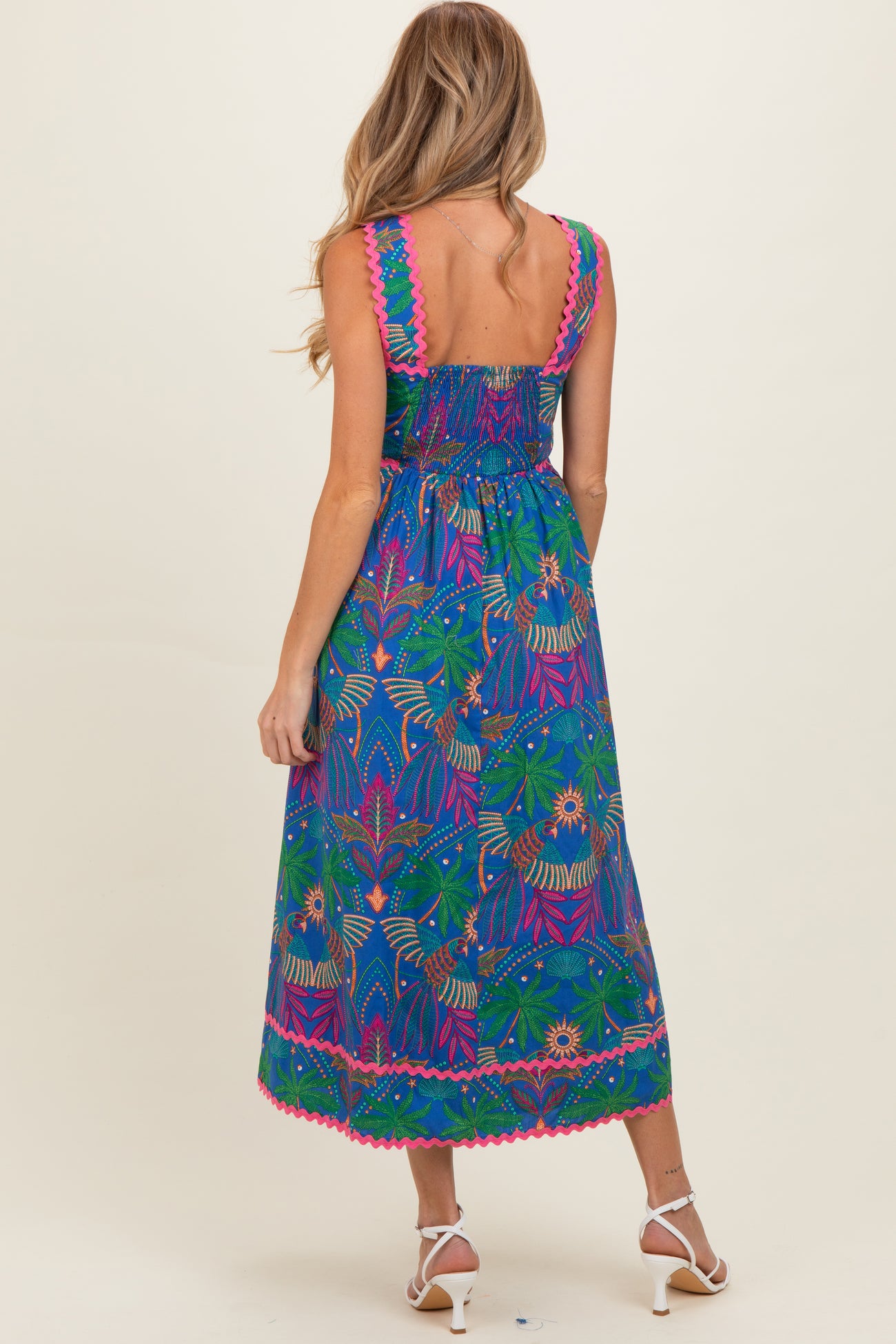 woman wearing a colorful patterned maternity maxi dress with a smocked back and vibrant trim