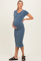 woman wearing a blue ribbed maternity dress and holding her baby bump