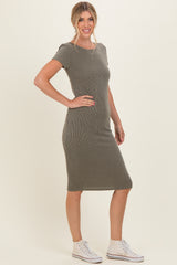 woman wearing a fitted olive green ribbed midi dress with short sleeves and white sneakers