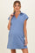 woman wearing a light blue maternity dress with a collar and short sleeves, showing her baby bump