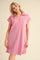 woman wearing a light pink short sleeve polo dress with a v-neck and relaxed fit