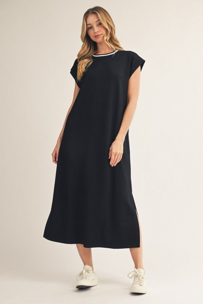 woman wearing a black cap sleeve maxi dress with side slits and white sneakers
