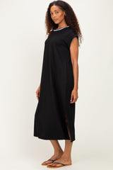 woman wearing a black sleeveless maxi dress with side slits and a white neckline detail