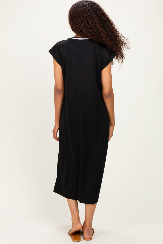 woman wearing a black short sleeve midi dress, visible from the back, with a relaxed fit and ankle-length hem