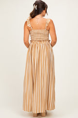 woman wearing a maternity maxi dress with ruffled straps and a smocked bodice in striped tan and white fabric
