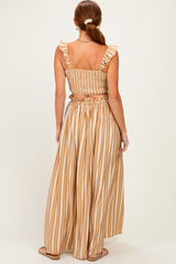 woman wearing a back view of a brown and cream striped two-piece set with ruffled details and a smocked back
