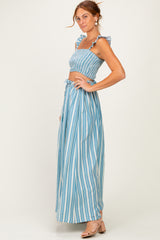 woman wearing a blue and white striped two-piece set with ruffled details and a flowy maxi skirt