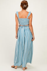 woman wearing a blue and white striped two-piece set with ruffled straps and a flowy maxi skirt