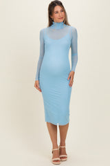 woman wearing a light blue maternity dress with long sleeves and a fitted silhouette, showcasing a baby bump