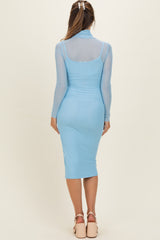 woman wearing a light blue long sleeve maternity dress with a fitted silhouette and sheer overlay, viewed from the back