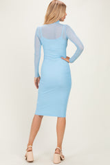 woman wearing a light blue long sleeve bodycon dress with a sheer panel detail, showing the back view