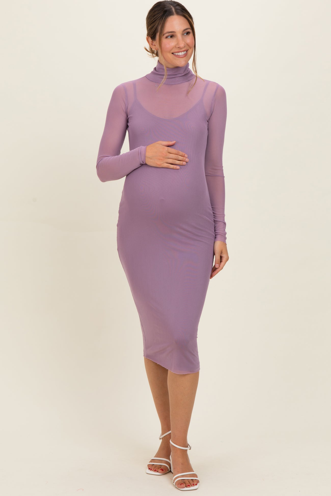 woman wearing a light purple long sleeve maternity dress with a high neck and baby bump visible