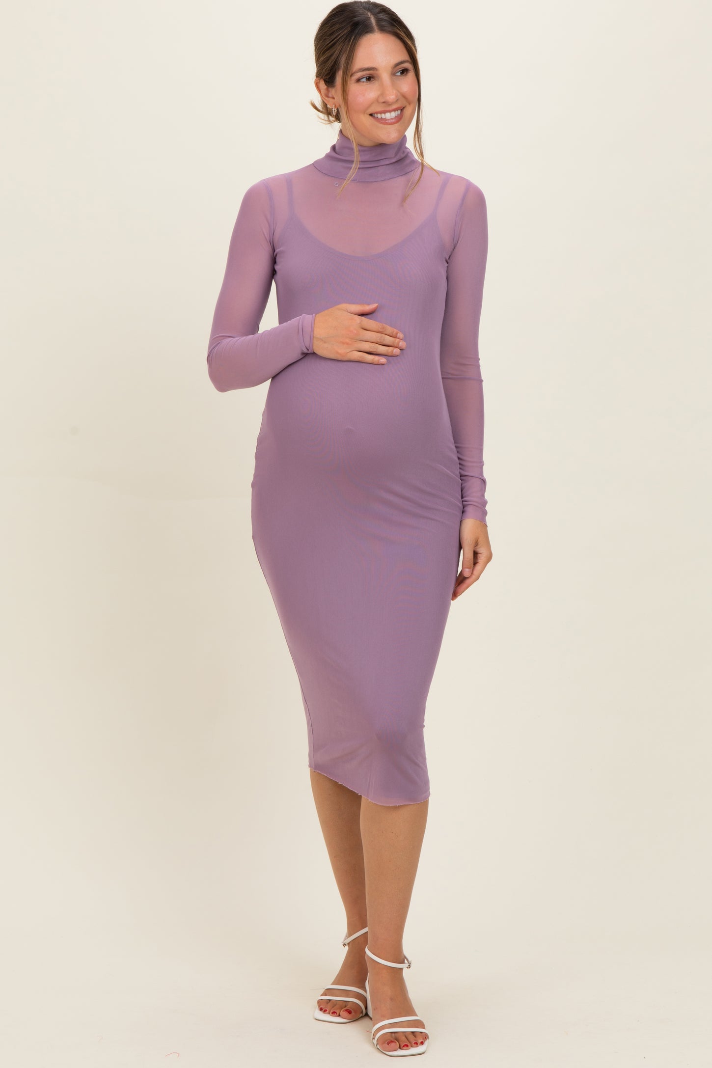 woman wearing a light purple long sleeve maternity dress with a high neck and baby bump visible