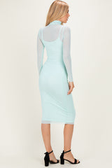 woman wearing a mint green long sleeve bodycon dress with sheer details and a below-the-knee length, viewed from the back