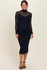 woman wearing a navy blue maternity dress with sheer long sleeves and a fitted silhouette, showing her baby bump