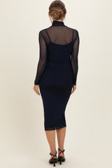 woman wearing a navy blue long sleeve maternity dress with sheer sleeves and a fitted silhouette