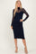 woman wearing a navy blue midi dress with sheer long sleeves and a fitted silhouette, posed with one hand on her hip