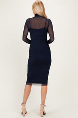 woman wearing a navy blue bodycon dress with sheer long sleeves and a fitted midi length, seen from the back