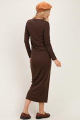 woman wearing a brown long sleeve maxi dress and a beret, viewed from the back