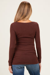 woman wearing a burgundy long sleeve maternity top showing the back detail and gathered sides