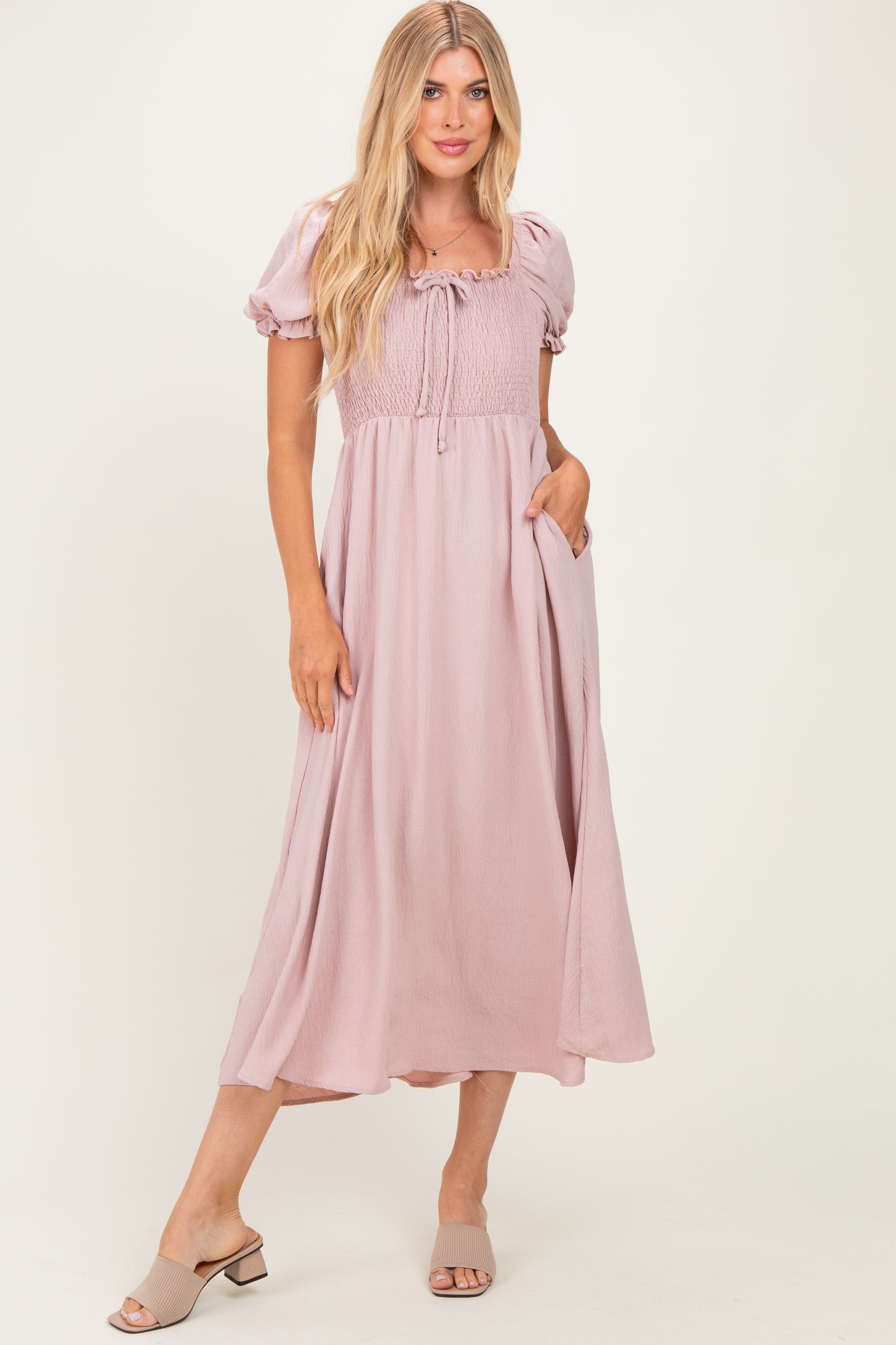 woman wearing a pink puff sleeve maxi dress with a smocked bodice and side pockets