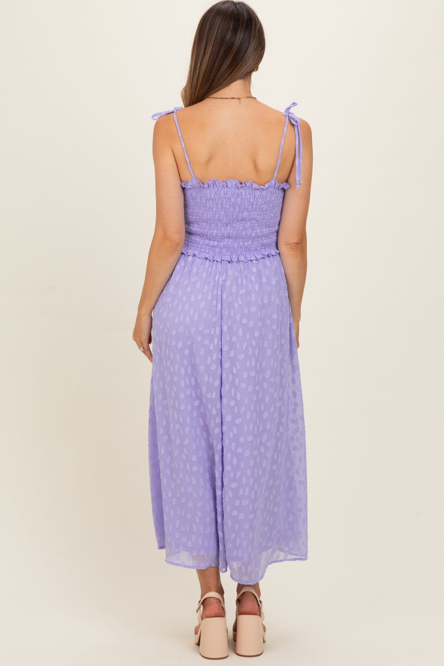 woman wearing a lavender smocked back maxi maternity dress with tie straps and polka dot pattern