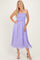 woman wearing a light purple, smocked sundress with shoulder ties and a flowy skirt