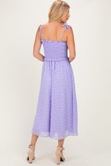 woman wearing a lavender midi dress with smocked bodice and tie straps, viewed from the back