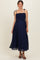 woman wearing a navy blue maternity dress with smocked bodice and adjustable straps, showcasing her baby bump