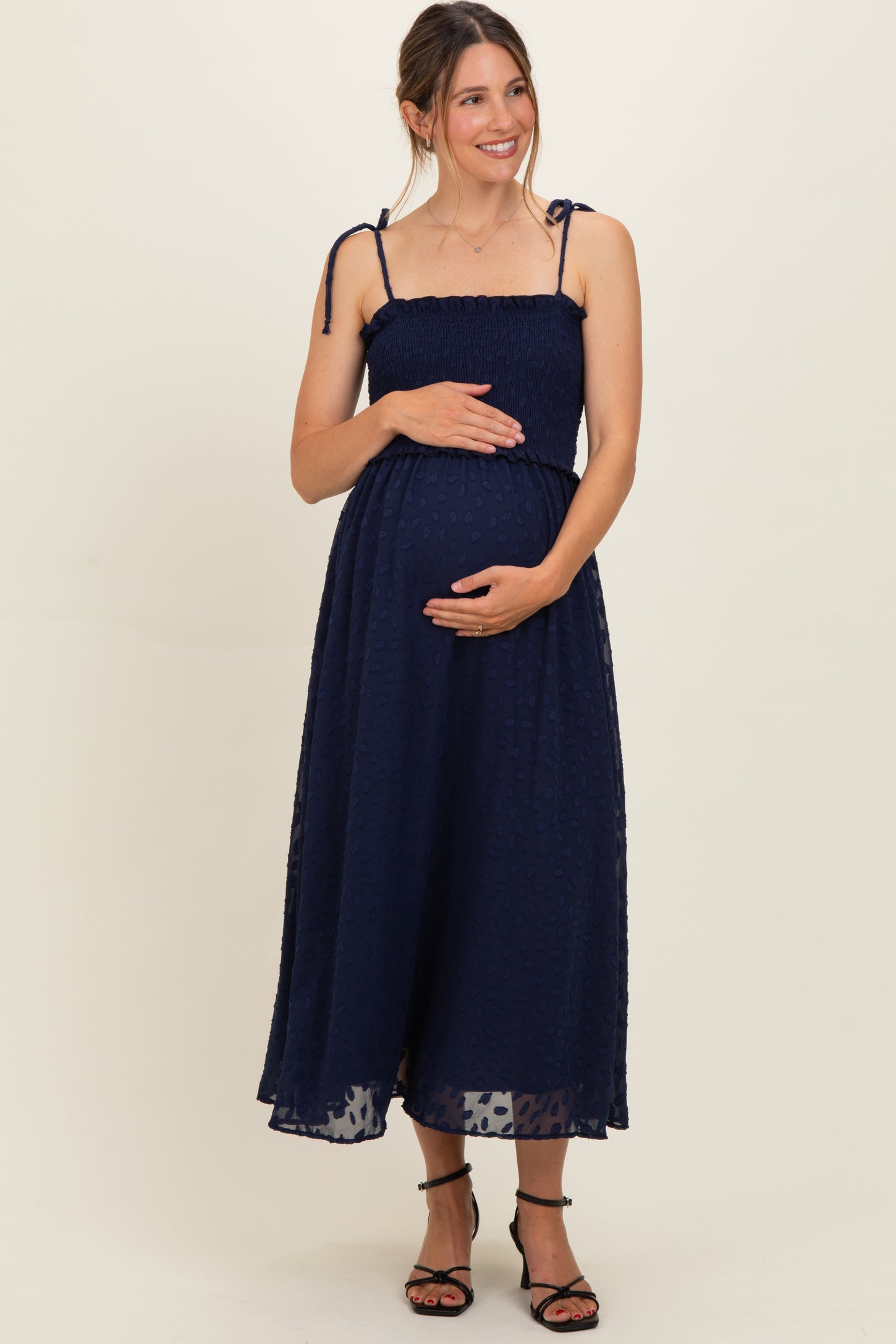 woman wearing a navy blue maternity maxi dress with adjustable straps and a baby bump visible