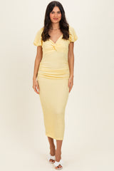 woman wearing a yellow ruched midi dress with short puff sleeves and a v-neckline