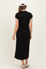 woman wearing a black maternity maxi dress with short sleeves and a long silhouette, viewed from the back