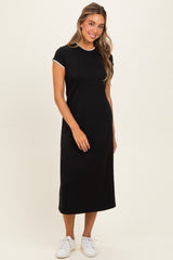 woman wearing a black short sleeve midi dress with white trim and white sneakers