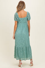 woman wearing a mint green lace maternity maxi dress with short sleeves and a tiered hemline