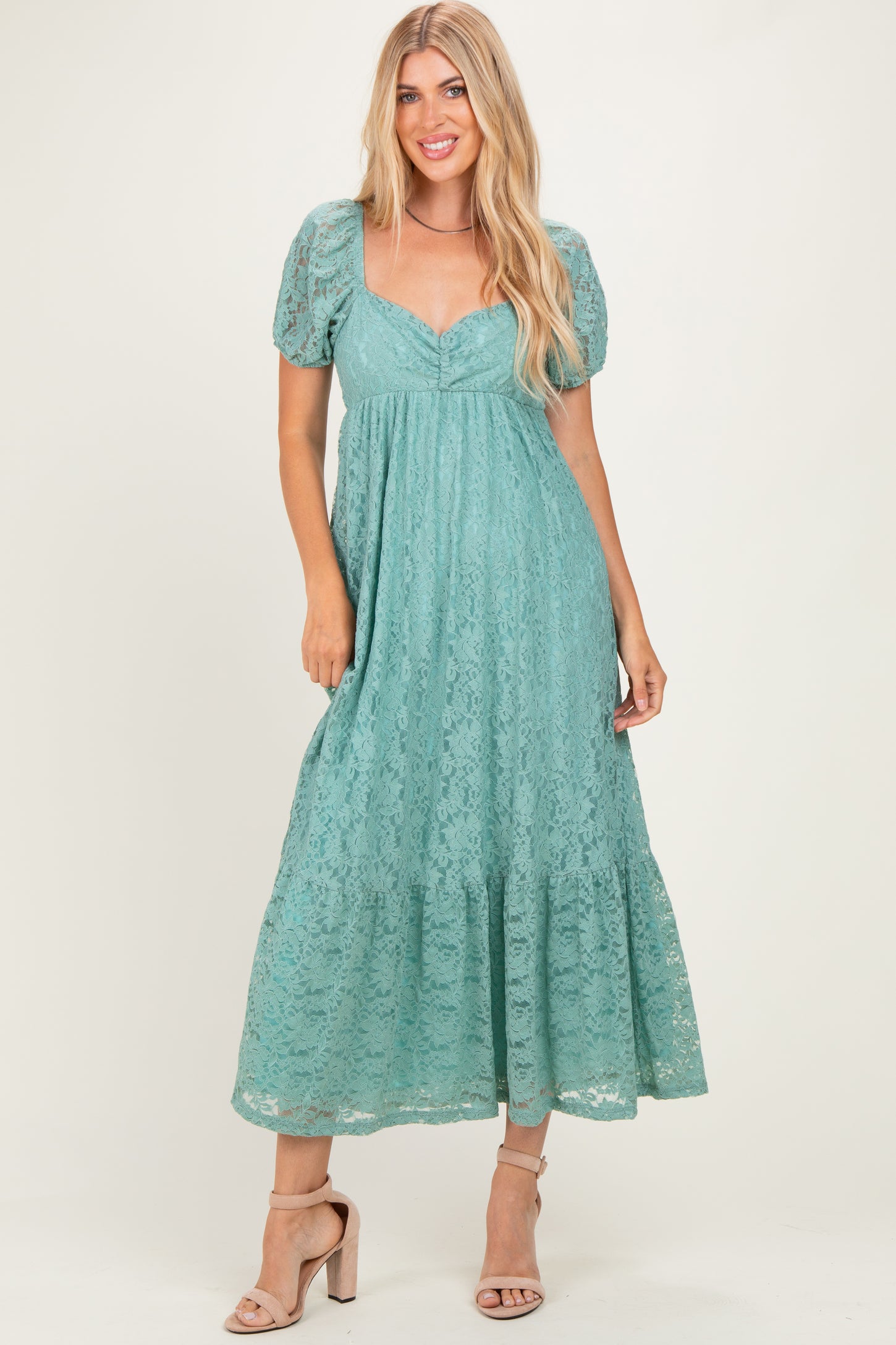woman wearing a teal lace maxi dress with puff sleeves and a tiered skirt
