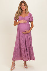 woman wearing a lavender lace maternity dress with puff sleeves and a tiered skirt, holding her baby bump