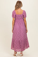 woman wearing a lavender lace maternity maxi dress with short puff sleeves and a tiered hem, showing a baby bump