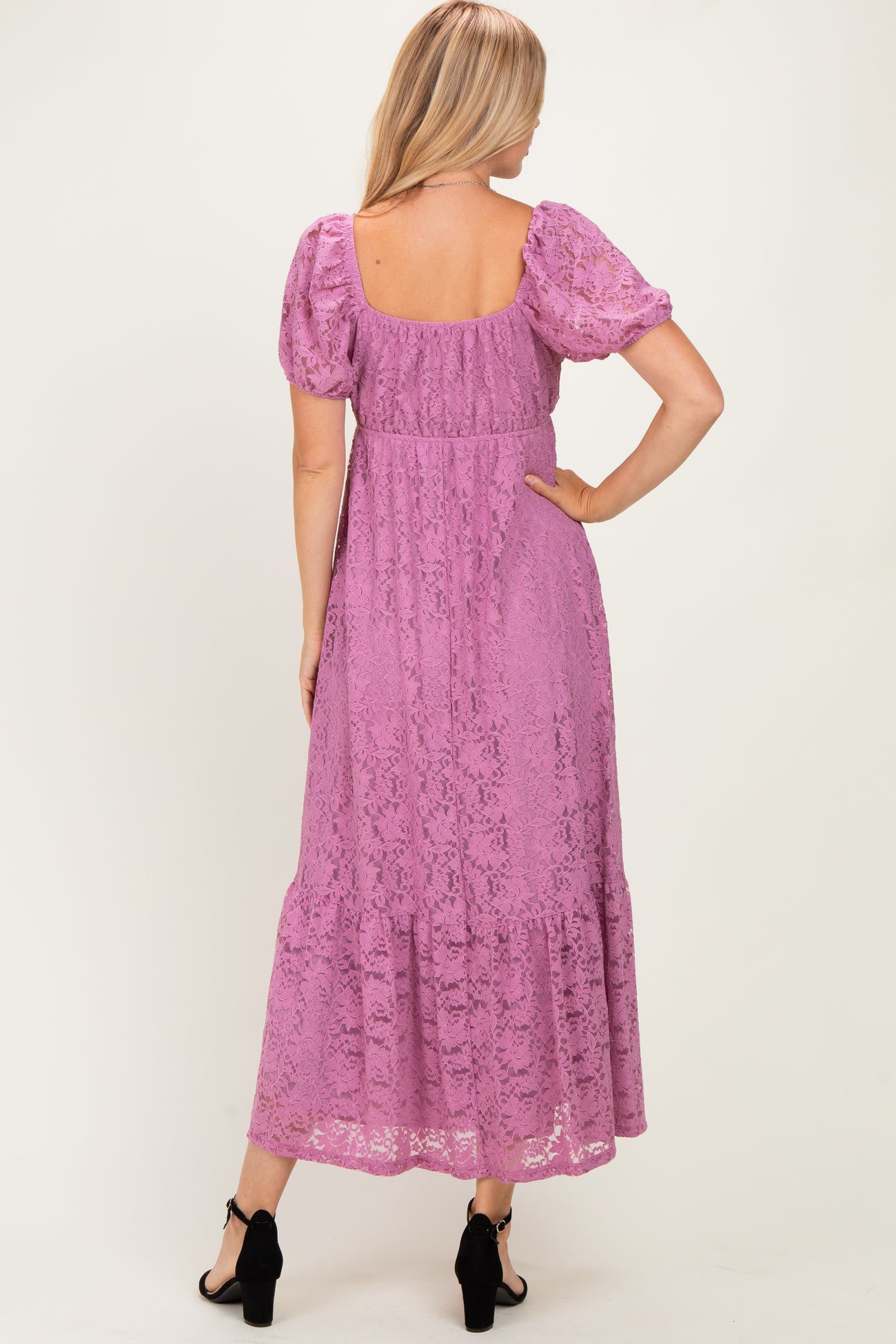 woman wearing a lilac lace maxi dress with puff sleeves and a tiered skirt, viewed from the back