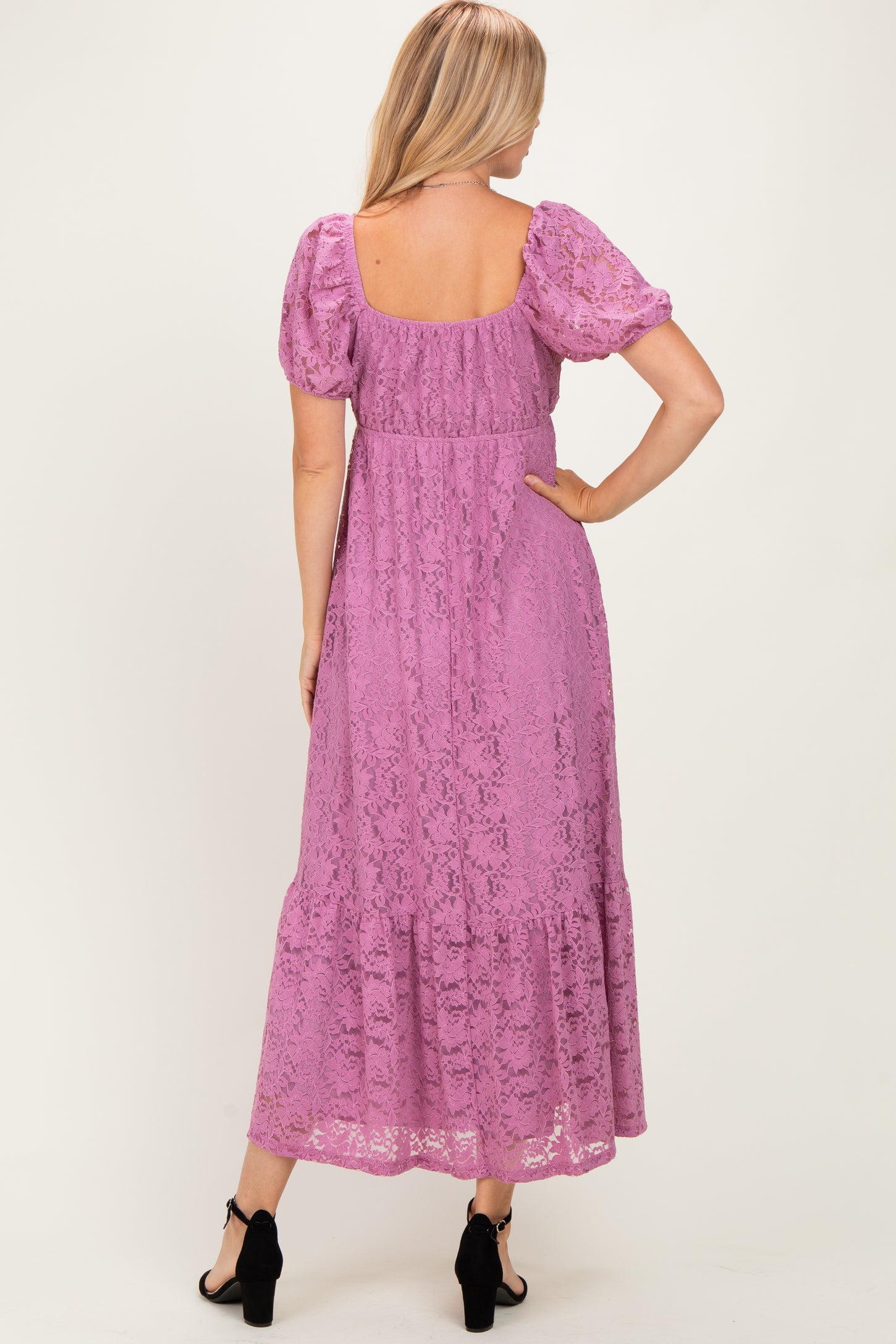 woman wearing a lilac lace maxi dress with puff sleeves and a tiered skirt, viewed from the back