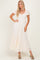 woman wearing a cream lace maxi dress with puff sleeves and a cinched waist, standing with one hand on her hip