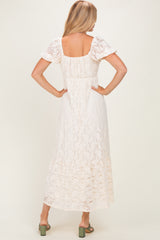 woman wearing a white lace maxi dress with short puff sleeves and a square back, seen from the back