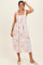 woman wearing a white floral print midi dress with pink flowers and shoulder ties