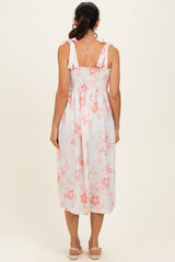 woman wearing a white floral midi dress with a smocked back and ruffled shoulder straps