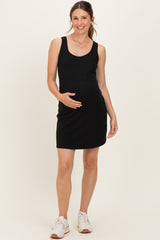 woman wearing a black sleeveless maternity dress and holding her baby bump
